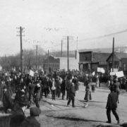 People crowd a street in Trinidad, Las Animas County, Colorado, in support of UMW coal miners on strike against CF&I. Letters on a business read: "[Pink] Lady."
