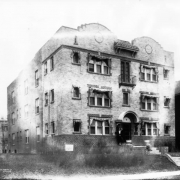 View of apartments at 1272 Pearl Street in Denver, Colorado; features pediments. Women are by the arched entry.