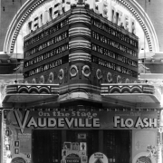 View of the Center Theater entrance and marquee at 1621 Curtis Street in Denver, Colorado; shows neon sign and lettering: "Vaudeville Sensational Nude Dancer Flo Ash," "Louise Fazenda - Maude Eburne Doughnuts and Society."