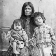 Studio portrait (sitting) of Native Americans (Chiricahua Apache) Gazie and her two children.