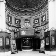 View of the Victory Theater in Denver, Colorado; shows the arched entry, ornate plaster work, and the ticket window. Display depicts a woman and reads: "Lights of Old Broadway, with Marion Davies."