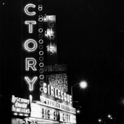 Night view of the Victory Theater in Denver, Colorado; neon signs and marquee read: "Victory, Girls, Fun For Adults Only, Girlesque, Acapulco Uncensored, Big Sin City, Spicy Films," and "Discount Credit Jewelers."