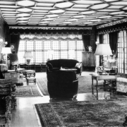 Interior view of the John Albert Ferguson house at 700 Washington Street in the Capitol Hill neighborhood of Denver, Colorado. Elizabethan style decor includes chairs, sofas, tables, lamps, heavy drapes, and ornate trim.