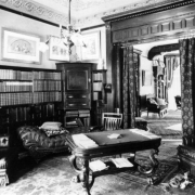 Interior view of the Mitchell Benedict residence (Lang & Pugh architects) in Denver, Colorado; decor includes tuck and roll upholstery, book cases, coved ceilings, and wood door frames.