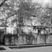 View of the Albert E. Humphreys residence at 1022 Humboldt Street in the Cheesman Park neighborhood of Denver, Colorado; shows a house with a walled yard, cornice, and a wrought iron and glass canopy.