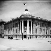 Exterior view of Benevolent & Protective Order of Elks, Lodge Number 17, 14th (Fourteenth) & California, Denver, Colorado; early automobile & horse-drawn carriage parked at curb, fire hydrant, streetlights; Hotel Auditorium, 14th & Stout, with sign atop roof adjacent to Elks' building.