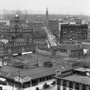 Rooftop view of downtown Denver, Colorado. Buildings include the Arapahoe County Courthouse, Orpheum Theater, Daniels and Fisher Tower, Kittredge Building, and the Majestic Building. Signs read: "The Stanley Motor Carriage Co.," "Orpheum Modern Vaudeville," "Kelly Springfield Tires," "Boss Rubber Co.," "Plymouth Hotel," and "Auto Equipment Co."