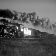 Freight, eastbound; 15 cars, 50 MPH, good smoke, with brilliant sunlight reflecting off the tender. Photographed: east of Hudson, Colo., February 15, 1937.
