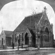 Exterior of the Evans Chapel, Denver, Colorado; a small grand, Gothic, stone structure features: a steep front gable with a stone cross, side entry vestibule, stained glass windows, and roof cresting; built in 1873-1878 by Dr. John Evans, (Colorado's second territorial governer) in memory of his daughter, Josephine Elbert; later moved to the Denver University campus for preservation.