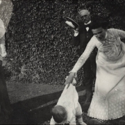 Mae Woodward, Frank Woodward's wife, holds onto her son by his clothes probably in Colorado. A man and a woman stand nearby.