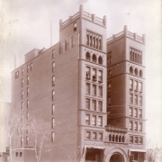 View of the Hotel Metropole and Broadway Theater at 18th (Eighteenth) Street and Broadway in Denver, Colorado. Shows Richardson Romanesque style building with side towers and light court. "Broadway Theatre" is over center arched doorway, "Hotel Metropole" and "Restaurant" over front entrances. Sign reads: "The Old Love and the New."