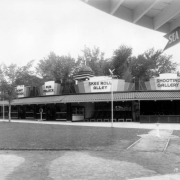 View of concession stands at Lakeside Amusement Park in Lakeside (Jefferson County), Colorado. Signs read: "Penny Arcade," "Fun Palace," "Skee Roll Alley," "Shooting Gallery," and "Sea Planes."