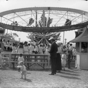 Children ride an attraction at White City Amusement Park (later called Lakeside) in Lakeside (Jefferson County), Colorado; toddlers play in the foreground.