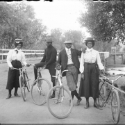 Outdoor portrait of well dressed Black men and women with bicycles on the Alameda Avenue bridge, in Denver, Colorado.