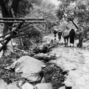 Men and women walk amid flood debris near South Boulder creek in Eldorado Springs, Colorado. The flood, in September of 1938, did major damage to houses and the Eldorado Springs resort.
