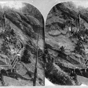 Visitors to the resort in Eldorado Springs, Colorado, ascend the "Crazy Stairs," which have been built on a sheer rock face. A lookout tower flying an American flag is visible at the top of the stairs.