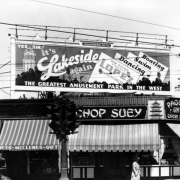 A Lakeside Amusement Park billboard tops a Chinese restaurant at 1700 Broadway Street, in Denver, Colorado. The sign reads: "Yes Sir It's Lakeside Again, The Greatest Amusement Park In The West," and "Now Playing Vincent Lopez," and "General Outdoor Adv. Co." Neon signs read: "Chop Suey Pagoda Inn."