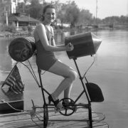 A woman sits on a bicycle-shaped peddle boat by Lake Rhoda at Lakeside Amusement Park in Lakeside (Jefferson County), Colorado.