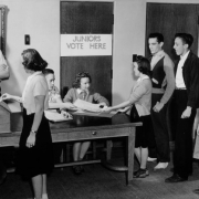 Boys and girls pass ballots and wait in line at East High School in Denver, Colorado. Sign reads: "Juniors Vote Here."