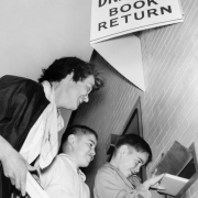 Mrs. John Baird and sons, John (8) and Michael (7), put books in a return slot at the Denver Public Library in the Civic Center neighborhood of Denver, Colorado.