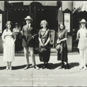 Photomontage of some of the cast of a musical revue by Bothwell Browne and the Browne Sisters. The cast members stand in front of the Orpheum Theatre at 1537 Welton in Denver, Colorado. Shows posters for the show pasted at the front entrance to the theater. Signs read: "William [?]" and "Coal." In the second exposure, the Browne Sisters pose in crocheted tops, one with long fringe, and skirts.