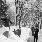 A man and two boys pose with snowballs in a snow drift for a man with a camera after the snowstorm of 1913 in Denver, Colorado.
