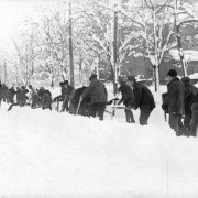A line of men with shovels and pickaxes work to remove snow after the snowstorm of 1913 in Denver, Colorado.