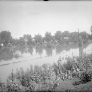 View of Cherry Creek floodwater in Denver, Colorado after the Castlewood Canyon Dam break; shows the Sunken Gardens under water.