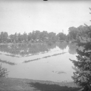 View of Cherry Creek floodwater in Denver, Colorado after the Castlewood Canyon Dam break; shows the Sunken Gardens under water.