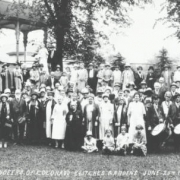 Group portrait of men, women, and children by a gazebo at Elitch's Gardens in Denver, Colorado; bass drum reads: "Veteran Drum Corps, Denver, Colo." Girls sit in front.