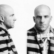 A. H. Davis, convict at the State Penitentiary in Canon City, Colorado, poses for his mug shot (front and profile) with a shaved head and  a jacket with wide, horizontal stripes, and number card: 14847. His crime was highway robbery.