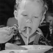 A boy eats noodles probably part of a hot lunch program at an unidentified school in Denver, Colorado.