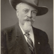 Studio portrait of William F. Cody (Buffalo Bill); he wears a coat and tie with a stick pin, a cowboy hat, and has a goatee and moustache.