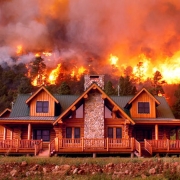 Flames from a new fire loom menacingly  behind a mountain home near Durango