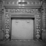 Interior view of the residence of T. B. Townsend, in Montrose, Colorado, shows an ornate fireplace surround with raised images of potted flowers along the sides and images of flowers on a branch across the top.