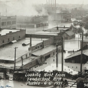 View of flooded buildings, debris and flood water from the Arkansas River in Pueblo (Pueblo County), Colorado. Shows submerged commercial buildings, houses and telephone poles in Goat Hill (Tenderfoot Hill) in northeast Pueblo.