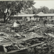View of metal and wood debris, mud and silt from flooded Fountain Creek washed over Denver and Rio Grande Western Railroad tracks near the 8th (Eighth) Street depot in Pueblo (Pueblo County), Colorado.