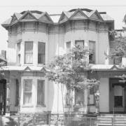 View of 2613-2619 California Street in the Five Points neighborhood (Curtis Park) of Denver, Colorado. Constructed in 1887, the two-story Italianate duplex has a rusticated stone foundation, brick walls, and a mansard roof with elaborate bracketed wooden jig-sawn friezes and cornices, topped with pediment shaped windows. Both duplexes have bays and porches.The building is listed on the National Register of Historic Places as a contributing resource to the Curtis Park-Champa Street Historic District.