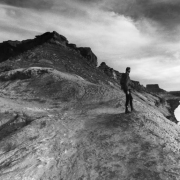 A cyclist stands looking at the Green River near Ft. Bottom on the White Rim Trail in Canyonlands National Park. The trail which runs through rough and rugged country for over one hundred miles is in the Island in the Sky District of Canyonlands. The p...