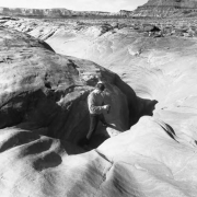 A cyclist traveling the White Rim Trail checks out The Black Crack. At many places along the trail a small crack opens up,becoming, eventually, a vast canyon. During its hundred mile length many canyons appear like this beside the trail. The White Rim ...
