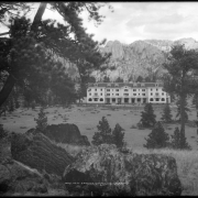 Exterior view of Stanley Hotel under construction, Estes Park, Colorado; hotel built by Freelan Oscar Stanley and completed in 1909; stone  masons or workmen building rock wall.