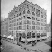 Exterior view Kittredge Building, 16th (Sixteenth) and Glenarm Streets, Denver, Colorado; constructed in 1890-1891; street level businesses include Franco-American Food Company, Columbia Phonograph Company, and Knight-Locke Piano Company; Dentist Robert Kettner on second floor; Mountain Electric Company building on Glenarm adjacent right; shows bicycles, horsedrawn wagon and carriage parked at curb, and street railway car tracks.