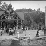 Manitou Springs, Colorado, trolley stop (Colorado Springs and Interurban Railway) with Soda Springs drinking fountain, center foreground; shows men and women fashionably attired gathered around springs and trolley  shelter, and Cliff House Hotel, one block from Soda Springs.
