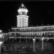 Night time view of Casino and Tower, "White City" (later called Lakeside Amusement Park), Lakeside, Colorado near Denver; illuminated building and tower, benches in front of casino, near bandstand.