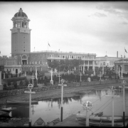 View across Lake Rhoda, the "White City" (later called Lakeside Amusement Park), Lakeside, Colorado, near Denver; shows bandstand or pavilion (gazebo), benches, Casino and tower, boats on shore, and miniature  railroad tracks around lake.