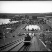 View of the "White City" (later called Lakeside Amusement Park), Lakeside, Colorado near Denver; northern view over park area taken from the Big Splash ride shows people in car on water ride, others standing on deck, main entrance with tower and casino, bandstand or pavilion (gazebo) with benches, Lake Rhoda, miniature train tracks, ball room, boat house, and rink.