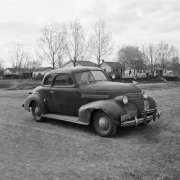 View of a 1939 Chevrolet Deluxe coupe automobile in (probably) Denver, Colorado.