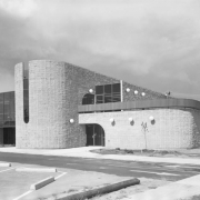View of the modernist style Bear Valley Branch of the Denver Public Library (Anderson, Barker, and Rinker Architects) at 5171 West Dartmouth Avenue in the Harvey Park South neighborhood, Denver, Colorado. Features curved brick walls and arches, glass atriums, and spherical lamps.