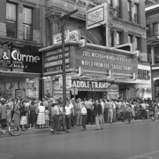 People crowd the 16th (Sixteenth) Street entrance of the Tabor Theater in Denver, Colorado. The marquee reads: "Joel McCrea and Wanda Hendrix on the Stage, World Premiere of Saddle Tramp."
