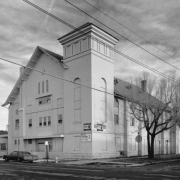 View of Congregation Emanuel at 2400 Curtis Street (at 24th - twenty fourth)  in the Curtis Park Neighborhood of Denver, Colorado; features include a square tower, blind arches, glass brick, a crown ornament, arched windows and a gabled roof and dormers.